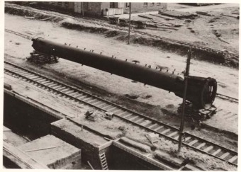 “Picture 1 shows a distillation column lying next to a railroad track. It is about 20 m long […]. Visible on the column are a large number of nozzles, to which piping will be attached later, after positioning, during assembly. In the background (center) is construction material in the form of planks and pipes.” '(Photo 1943/44, description by I.G. Farben defense counsel, Wollheim lawsuit, 1955)'© Central State Archive of Hesse (records of Wollheim lawsuit)
